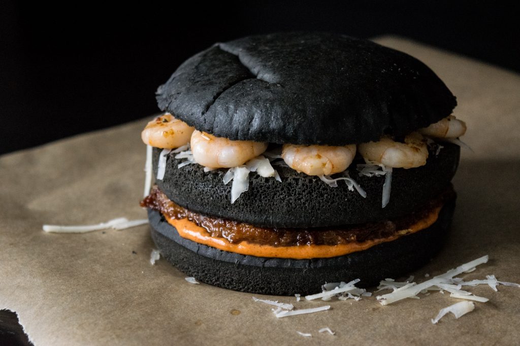 black burger with chorizo patty, machego cheese and shrimps