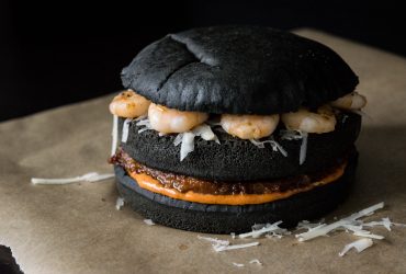 black burger with chorizo patty, machego cheese and shrimps